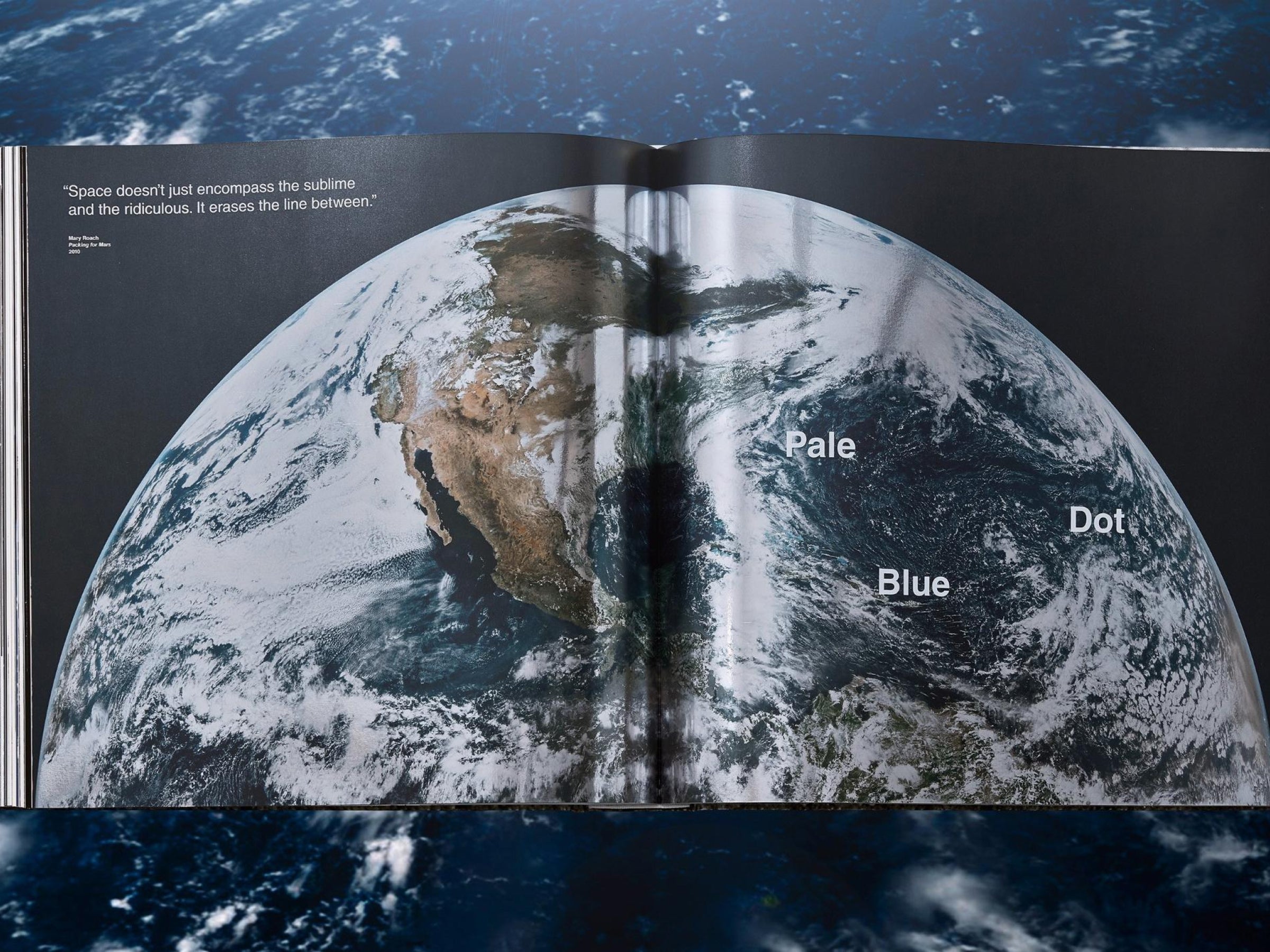 Two page spread featuring a dramatic view of Earth from space with the Pale Blue Dot label on the right page.