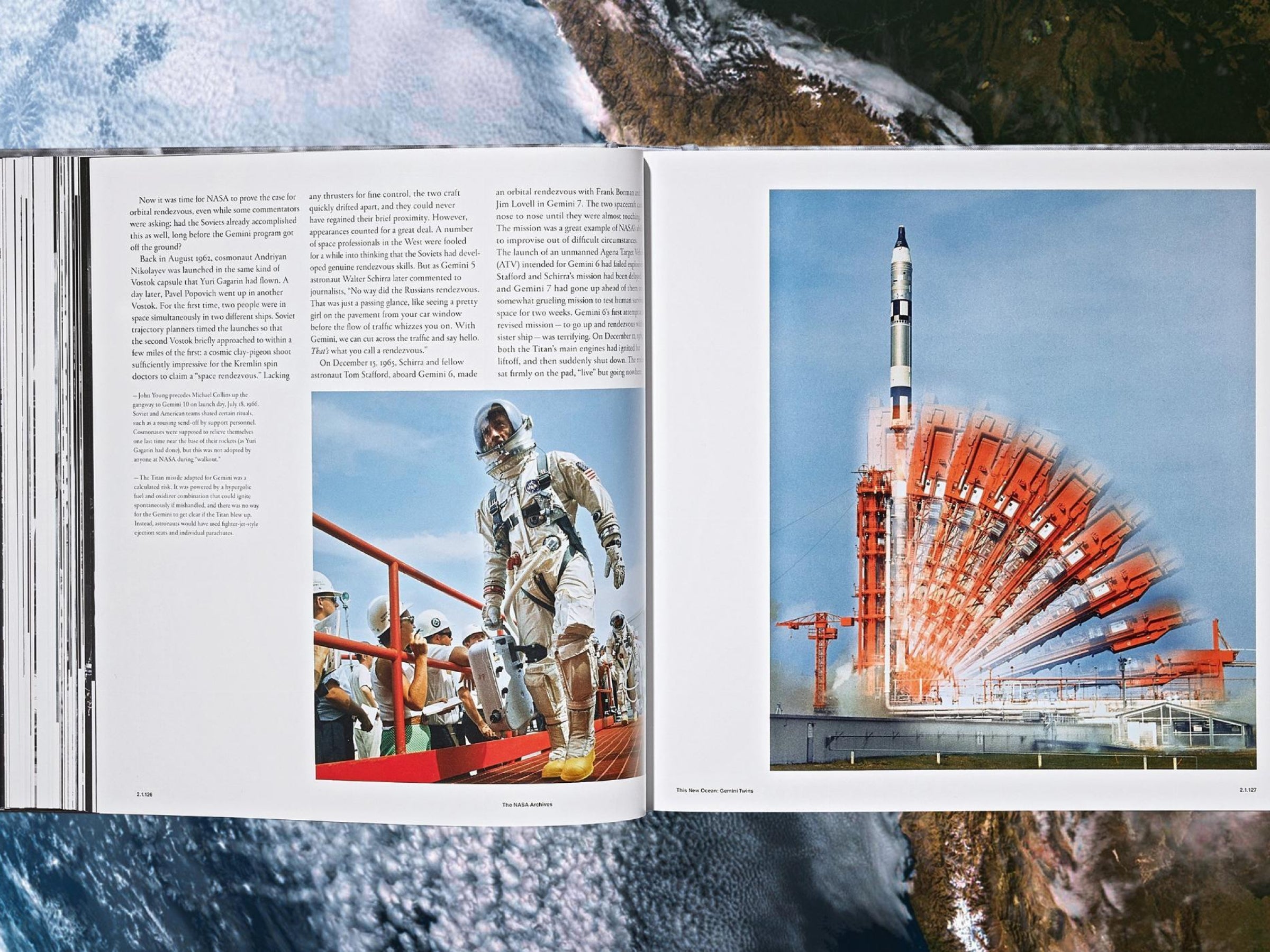Open pages of The NASA Archives book showing an astronaut beside a globe on the left and a rocket on the right.