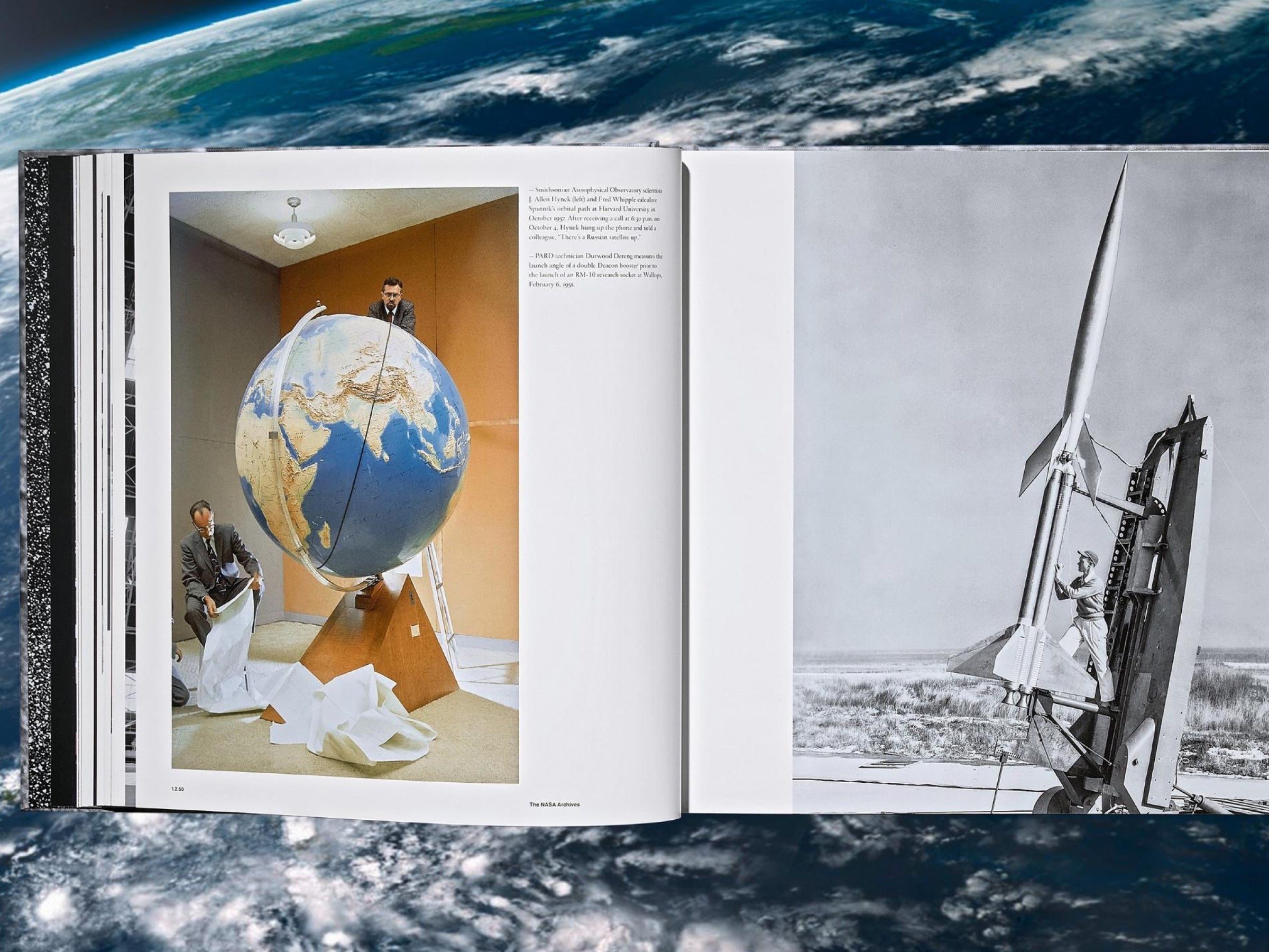 Open pages of The NASA Archives book featuring a globe being examined by scientists on the left and a launch rocket on the right.