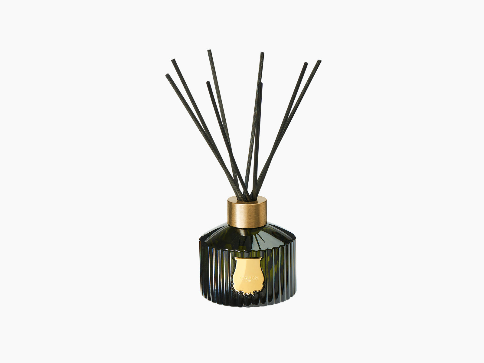 Gabriel diffuser in dark green glass with gold collar and black reed stems.