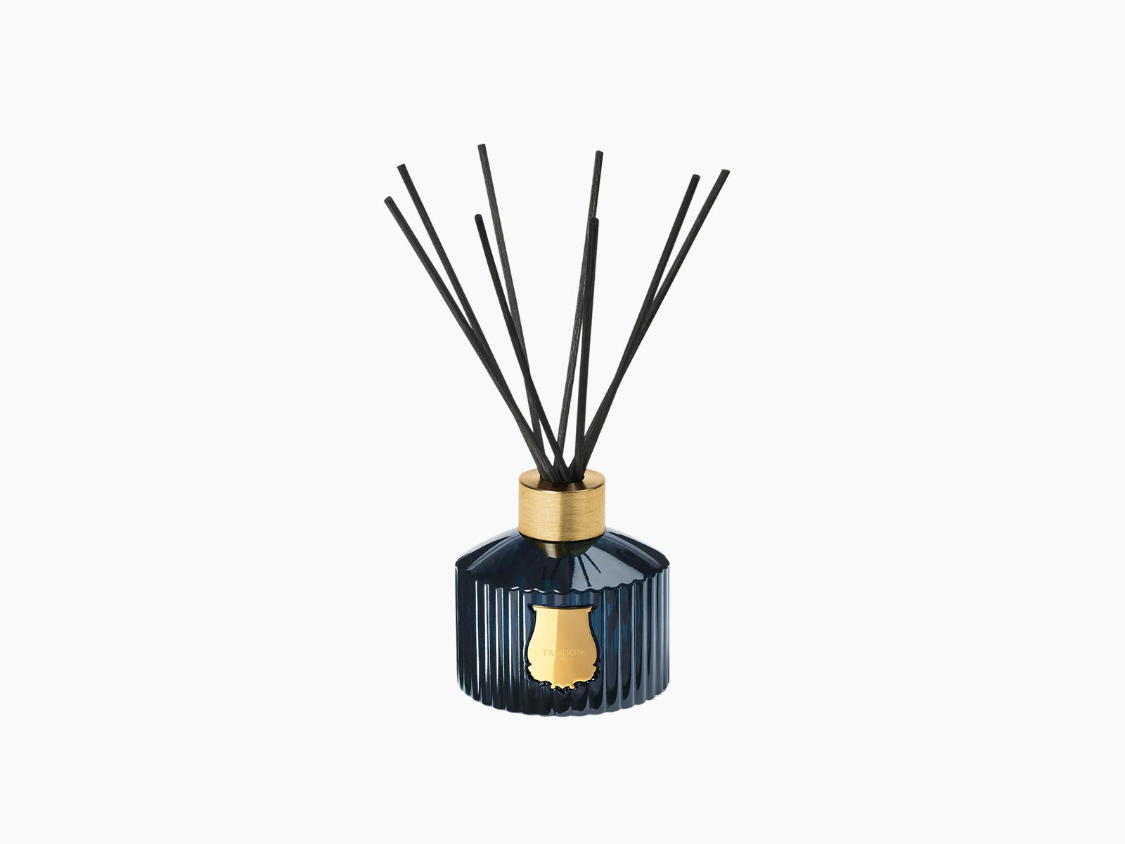 Reggio diffuser with multiple black reeds fanned up from a gold collar atop a blue ribbed bottle.