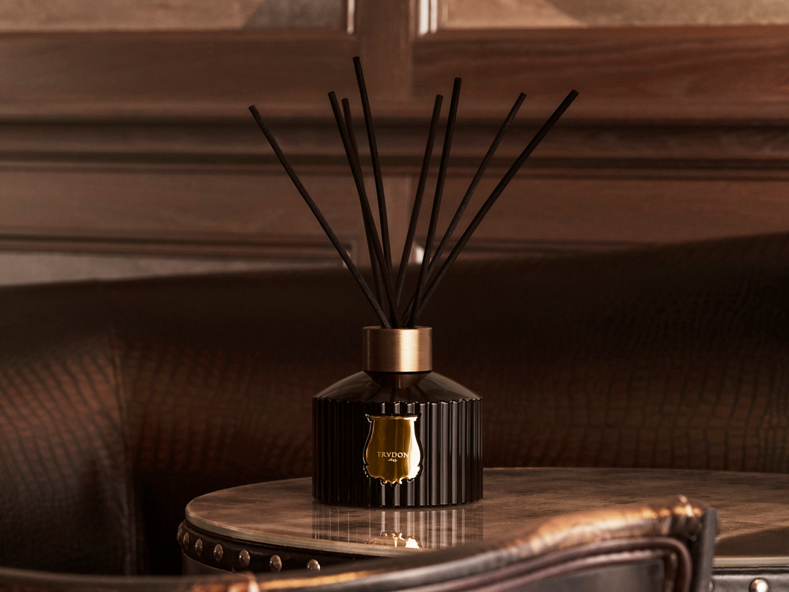 Grand Diffuser by Trudon in a ribbed black bottle with a gold collar and tall black reeds