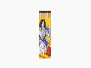 Tall yellow illustrated matchbox featuring a regal figure in white and blue robes, with matches protruding from the open top.