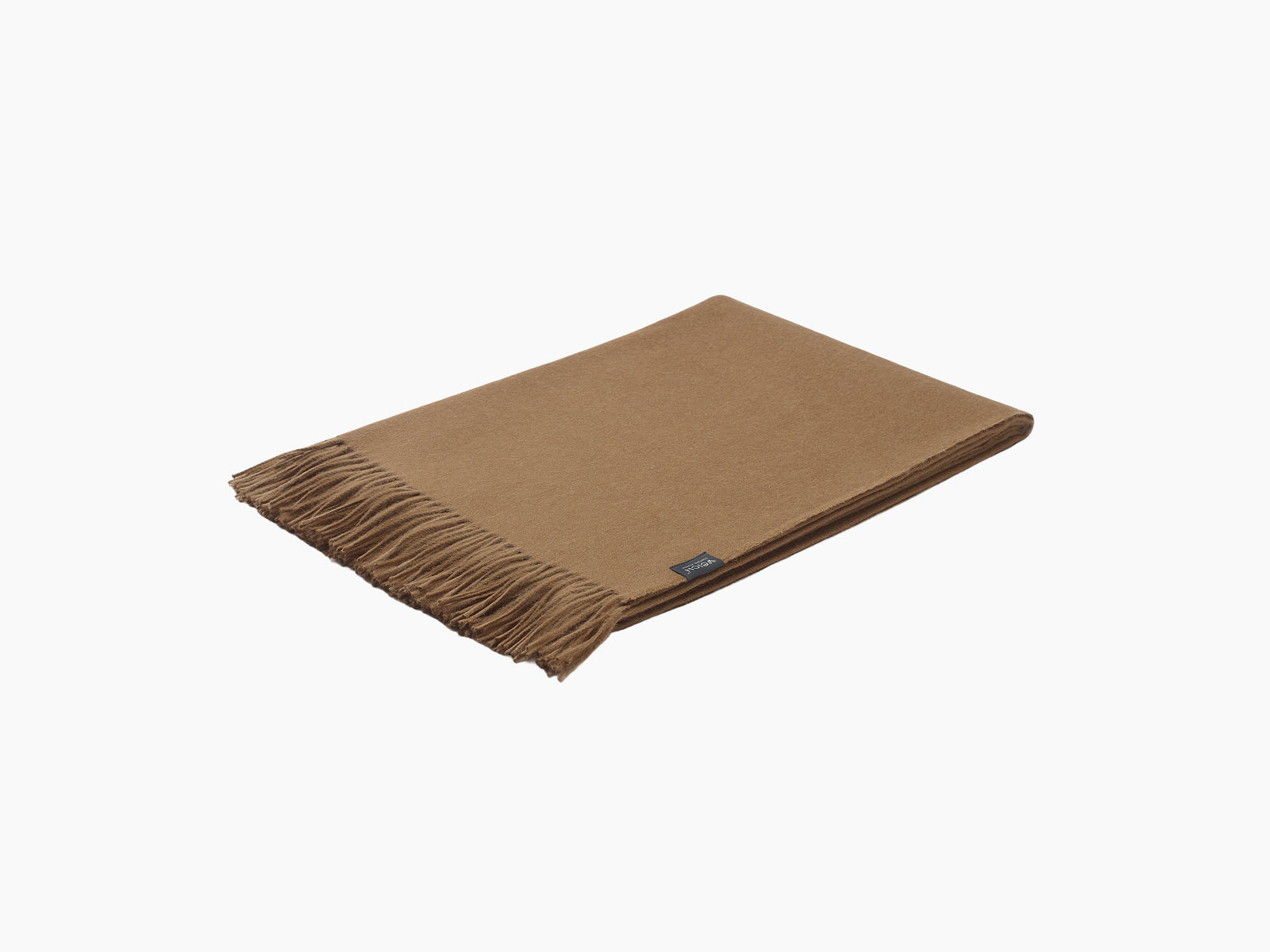 Brown alpaca blanket folded with fringe along one edge and a small label.