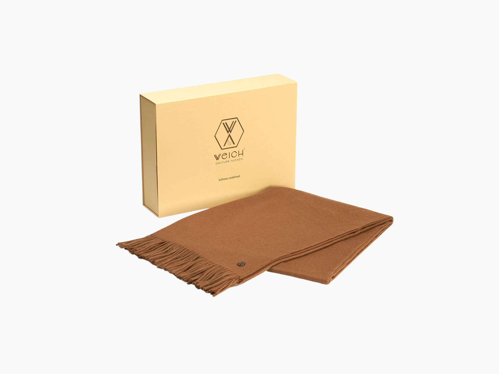 Brown Plaid ALMA alpaca blanket with fringe beside a beige gift box