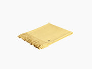 Yellow Plaid ALMA alpaca blanket folded with fringe on a white background