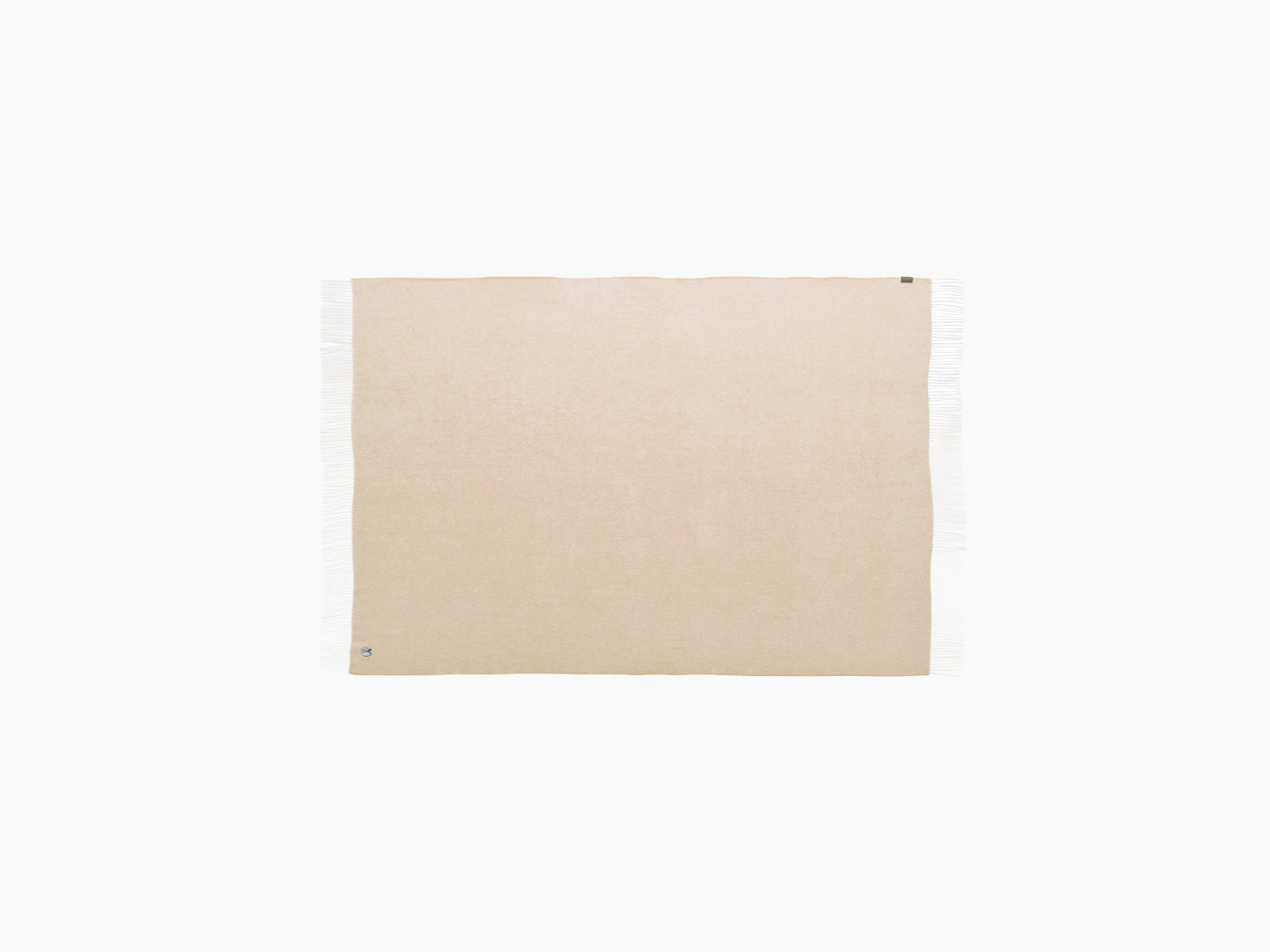 Beige fringed throw blanket laid flat against a white background