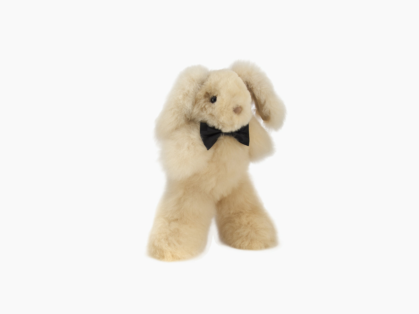 Cream plush rabbit with floppy ears and a black bow tie standing upright against a white background.