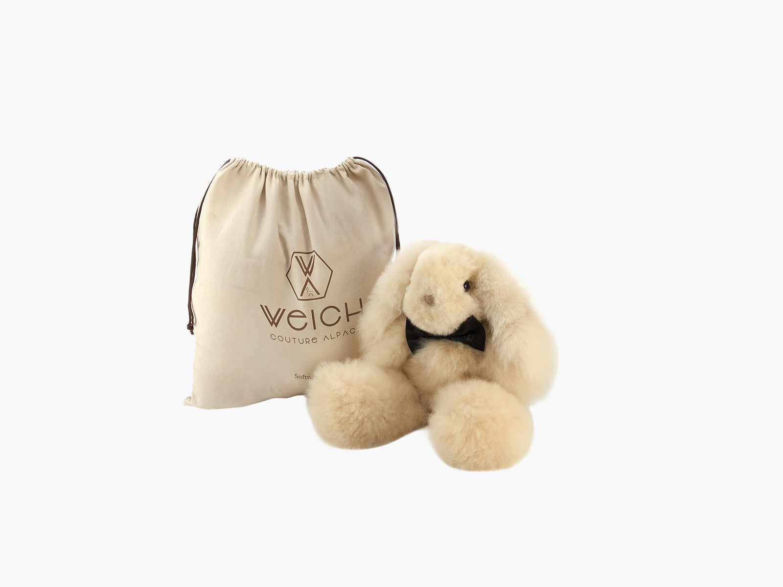 MILO rabbit plush made from fluffy alpaca fibre beside a beige WEICH drawstring bag.