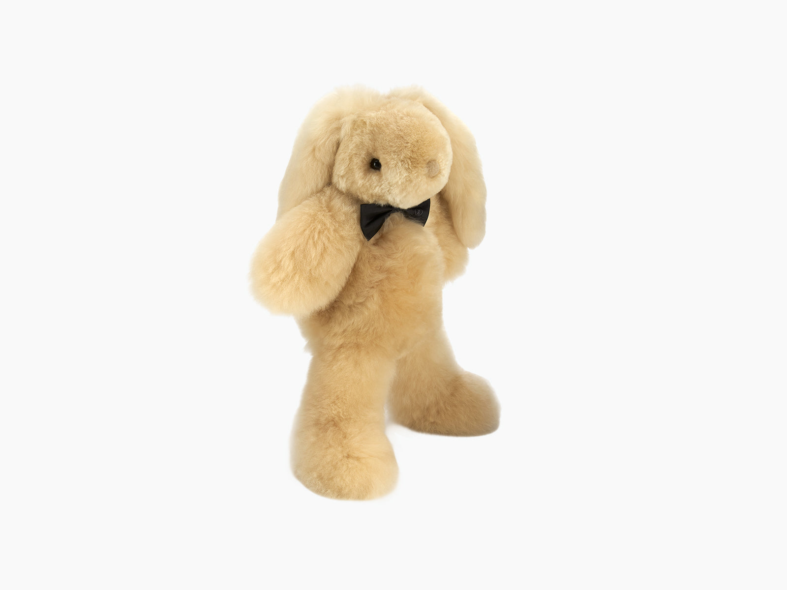Cream Milo rabbit plush standing upright with a black bow tie