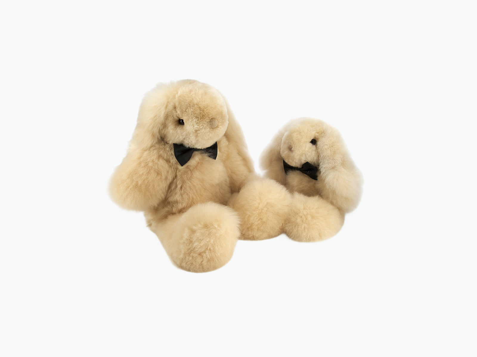 Two Milo rabbit plush toys in soft beige alpaca fur with matching black bow ties posed together.