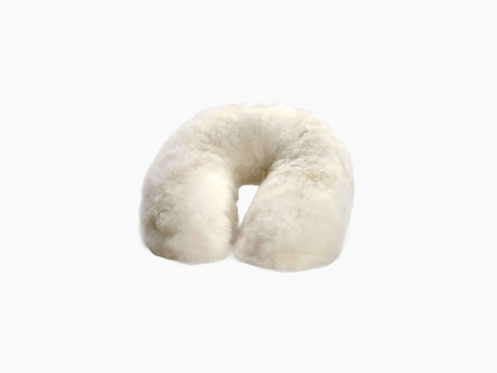 Close-up of ivory plush alpaca fabric with a silver brand tag nestled in the seam