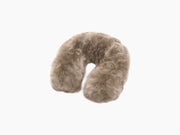 Close up of plush tan fur on a travel pillow with a brown leather tag.