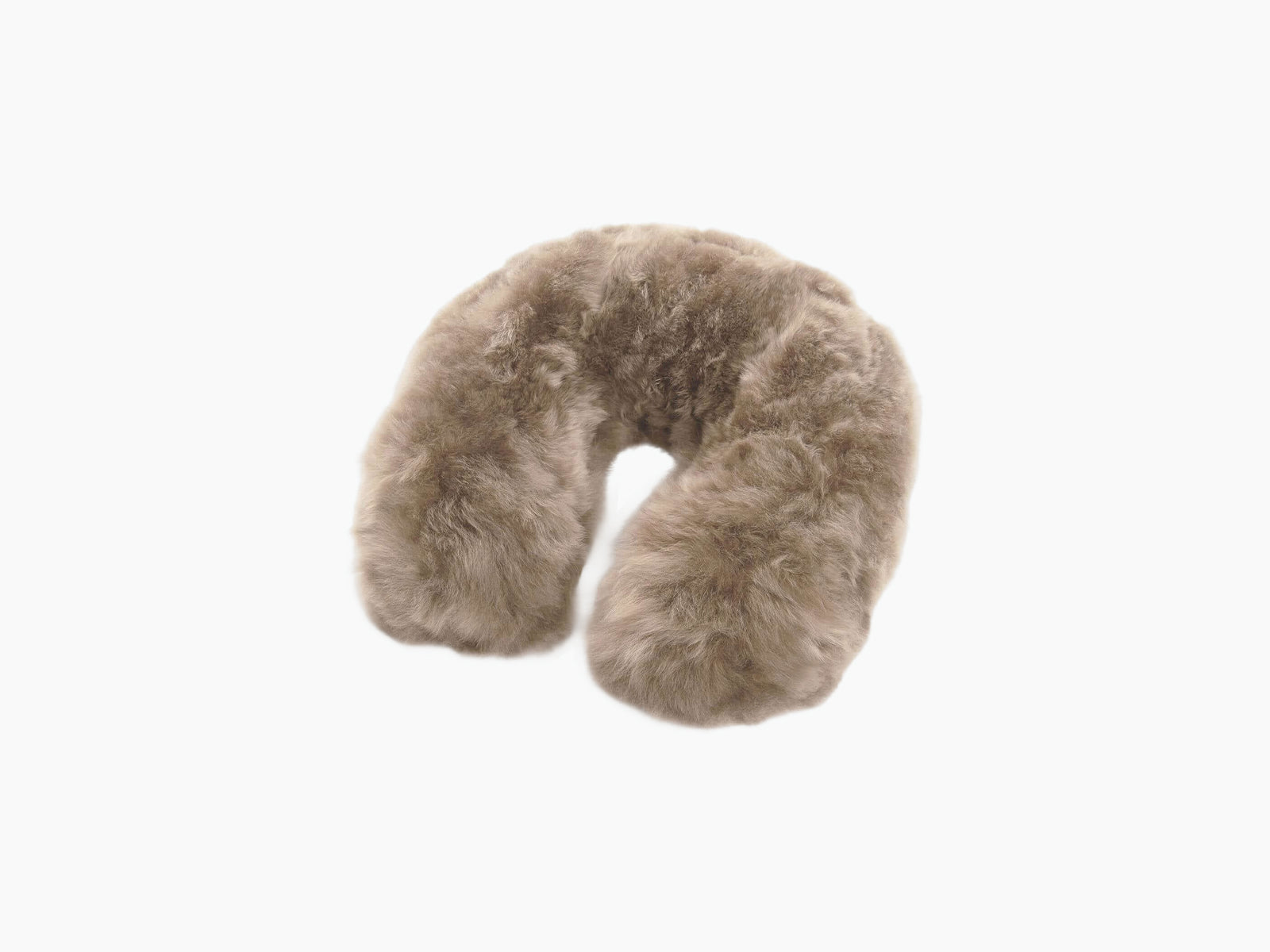 Close up of plush tan fur on a travel pillow with a brown leather tag.
