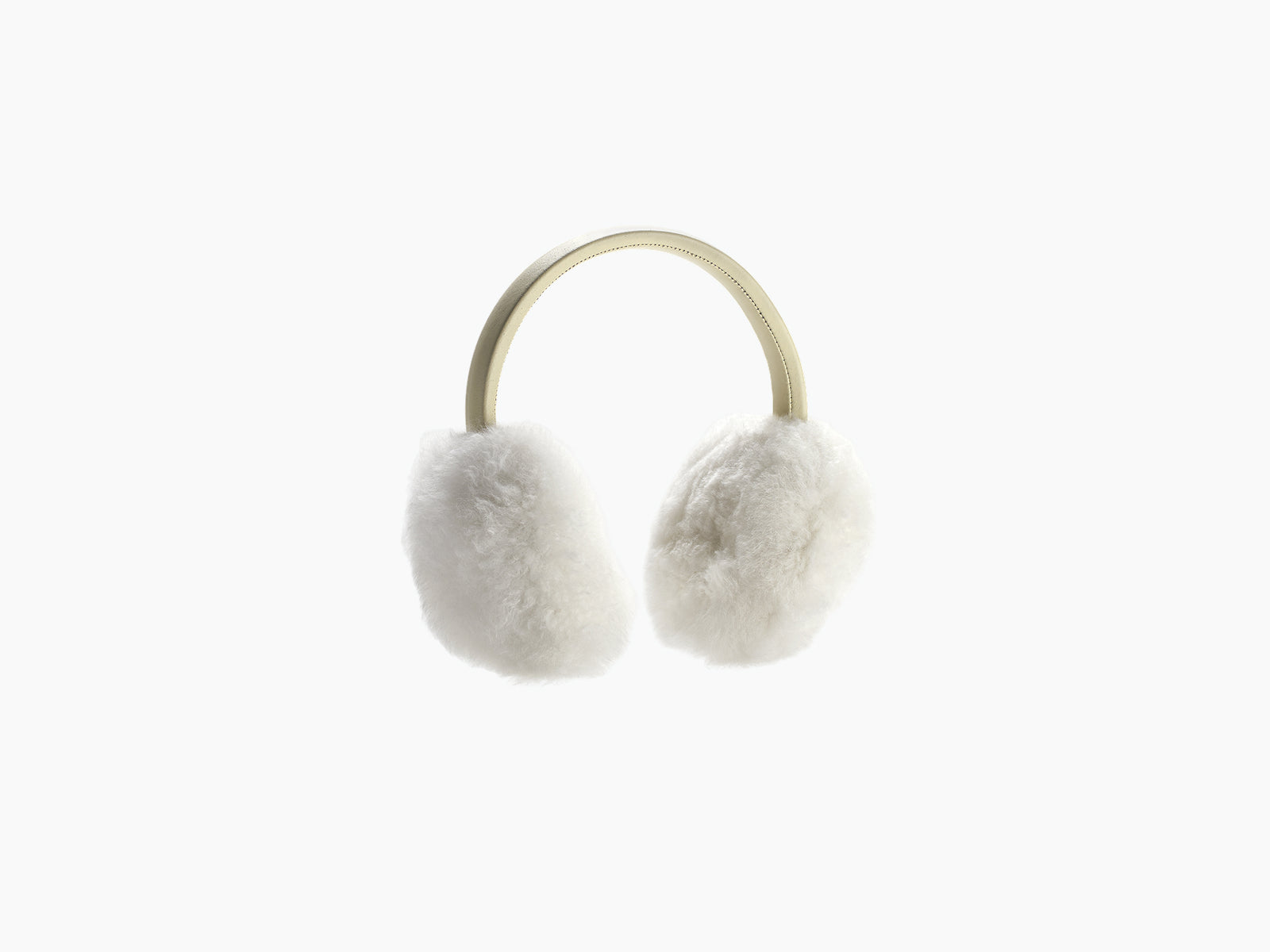 Woman wearing brown fluffy OLMO ear warmers outdoors in a snowy landscape