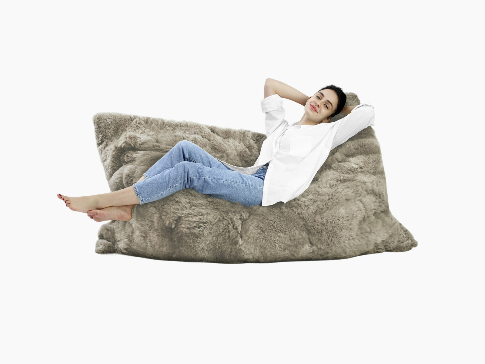 Woman reclining on a large plush fur Lounger REY in taupe with a relaxed pose