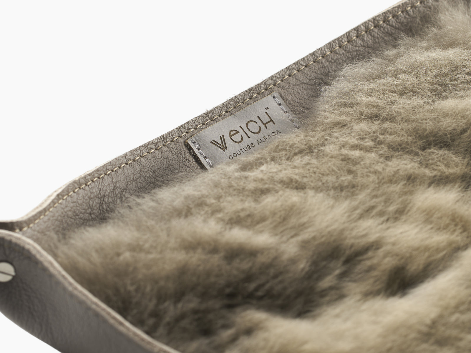 Close up of the alpaca fur lining inside a WEICH catchall tray showing stitched leather edge