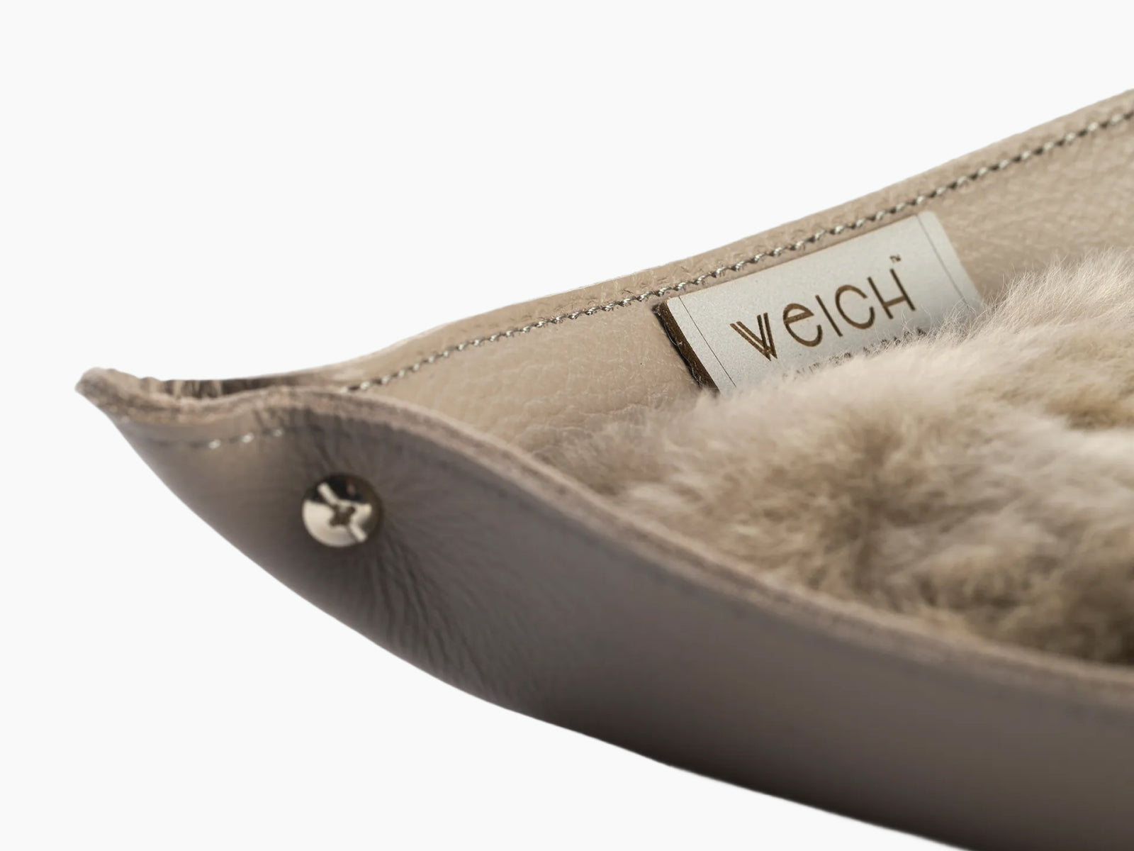 Detail of the beige leather edge with WEICH tag and plush alpaca interior
