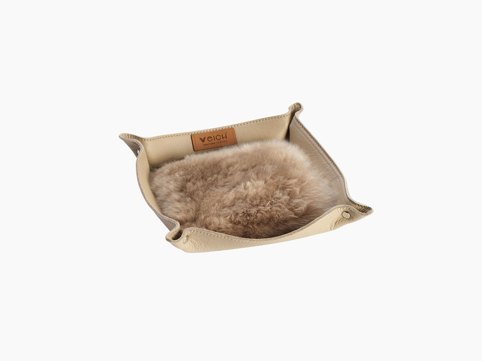 Interior view of the small beige leather tray lined with tan alpaca fur