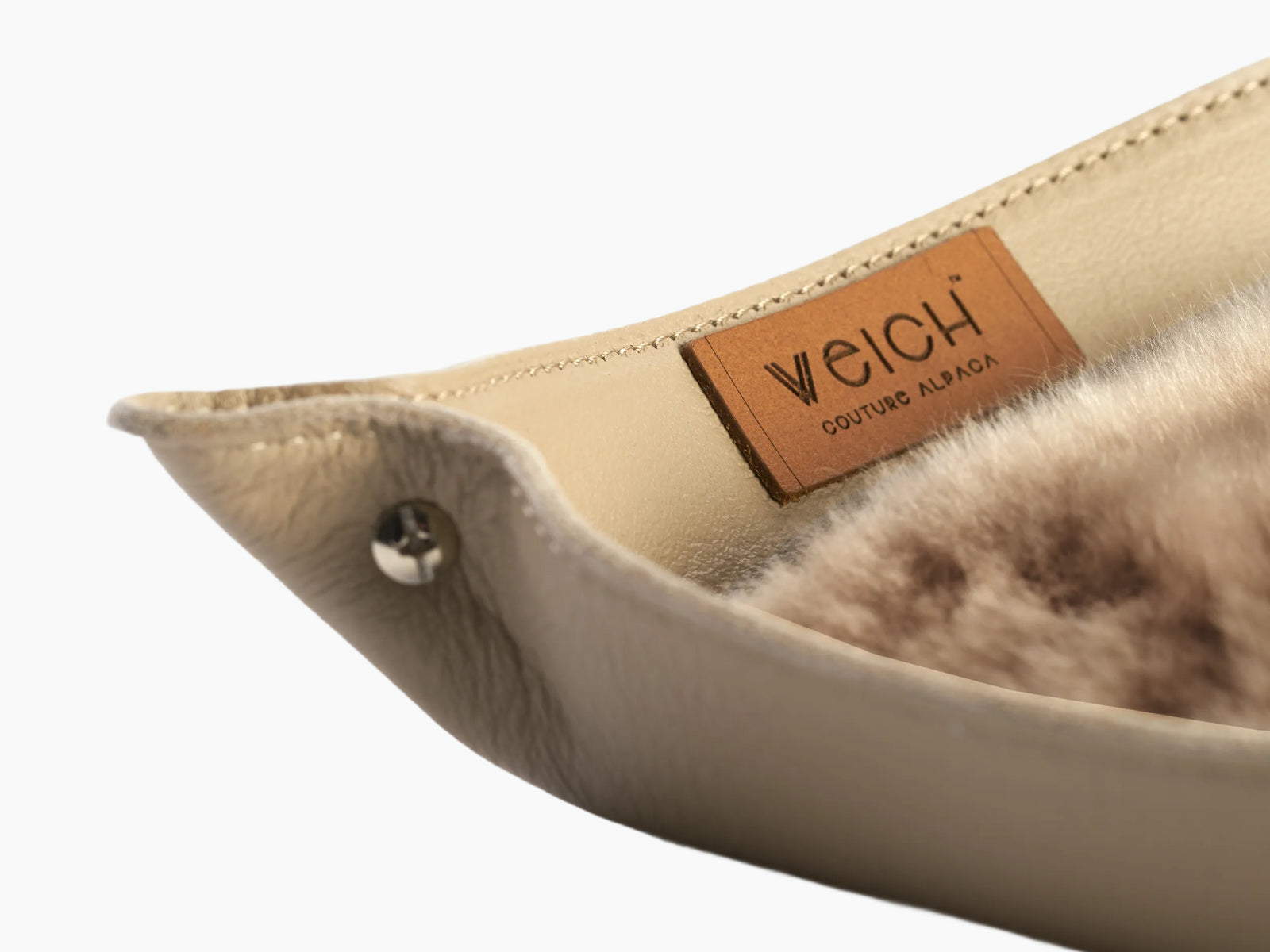 Close-up of a small WEICH catchall tray with beige leather edge and plush alpaca inlay.
