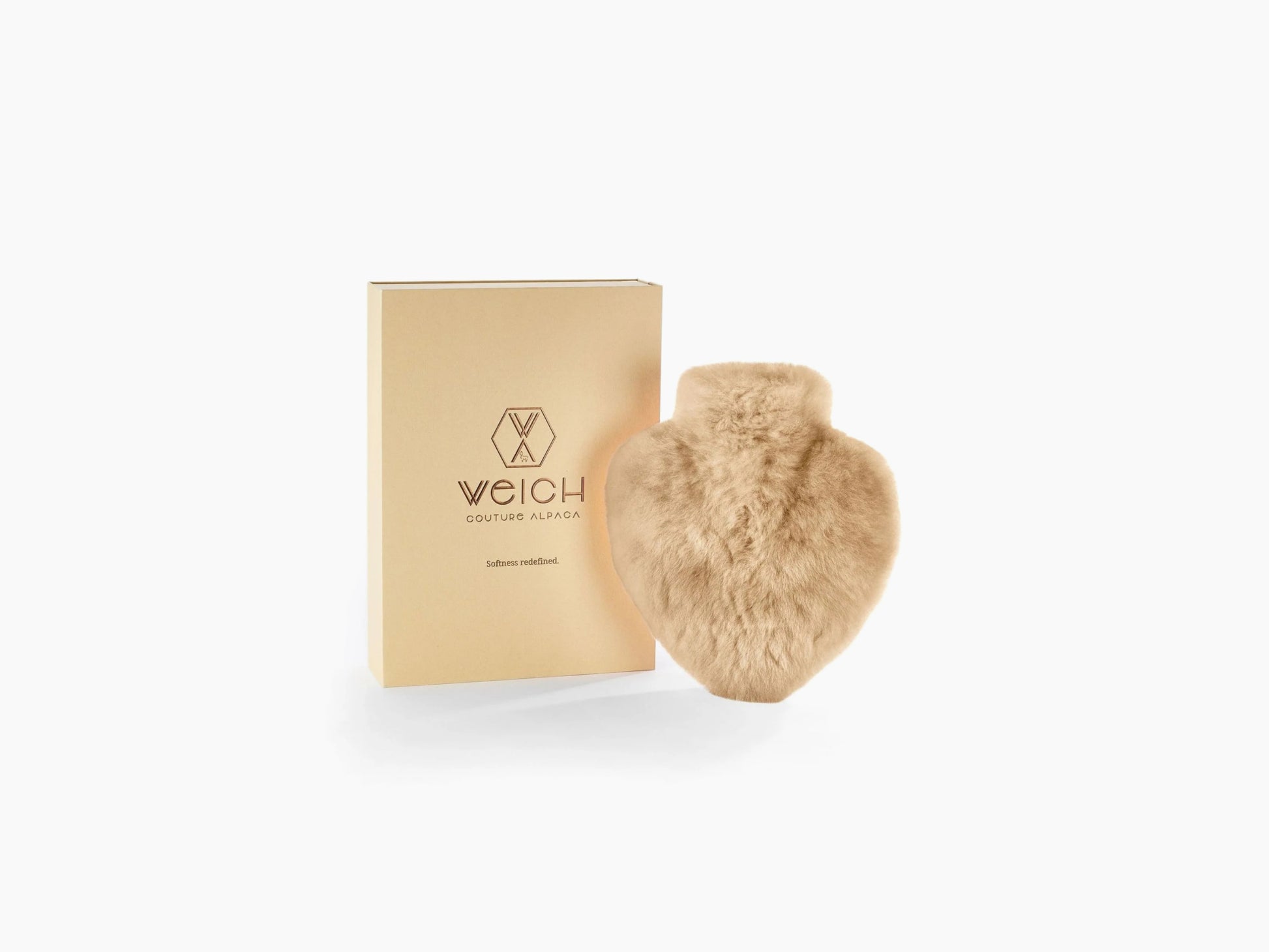 Alpaca fur hot water bottle beside a beige gift box with WEICH logo