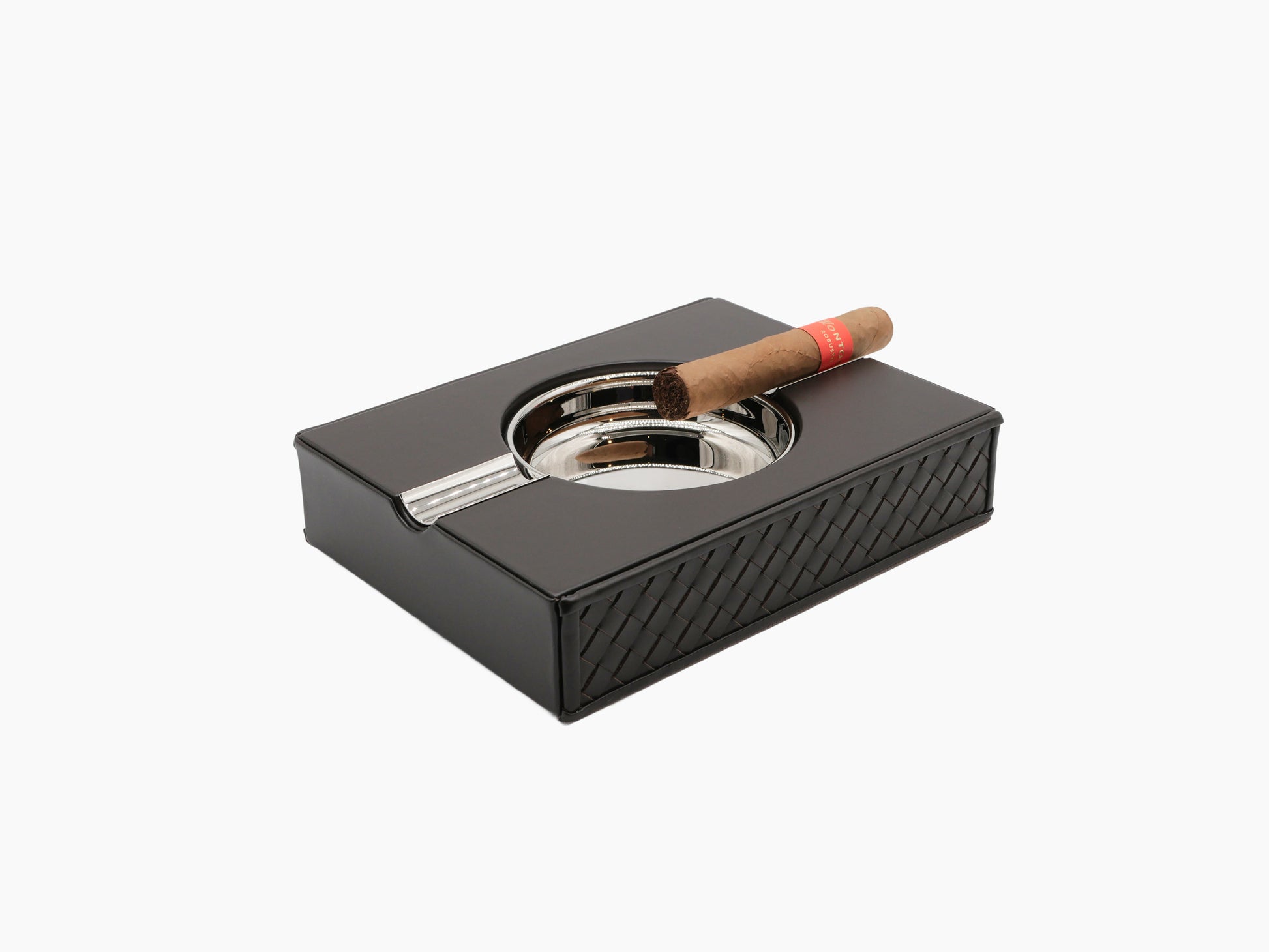 Zeno Handwoven Ashtray wrapped in black leather displayed at angle with a cigar resting on its chrome basin